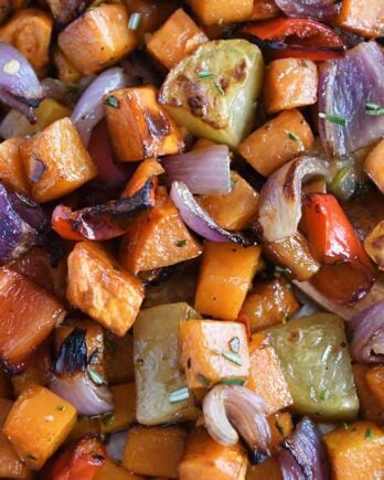 Roasted potatoes, red onions, red bell peppers and butternut squash on sheet pan.