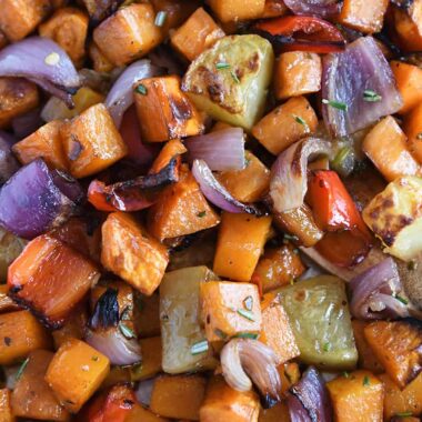 Roasted potatoes, red onions, red bell peppers and butternut squash on sheet pan.