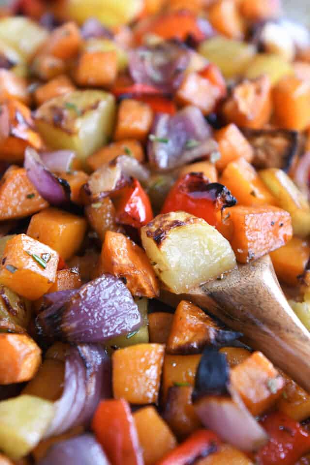 Roasted potatoes, red onions, red bell peppers and butternut squash on sheet pan.