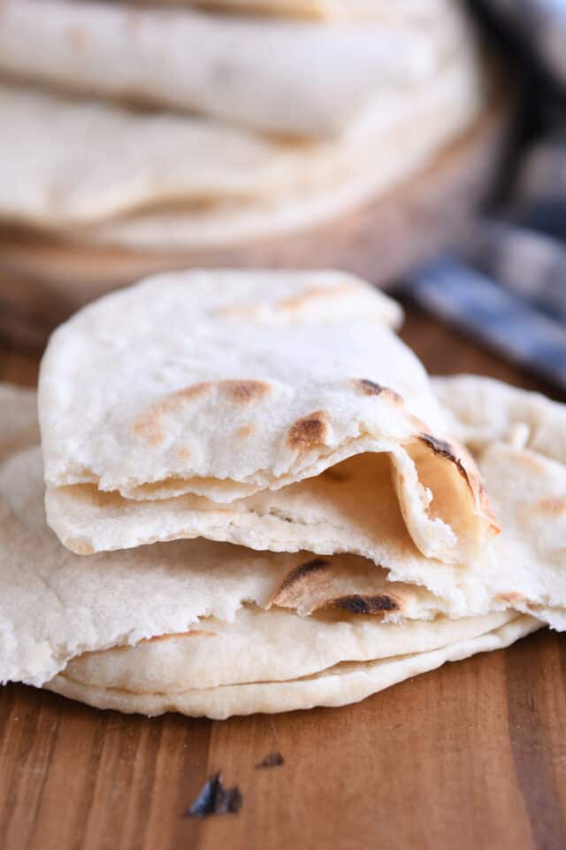 Ripped piece of flatbread on two other pieces of flatbread.