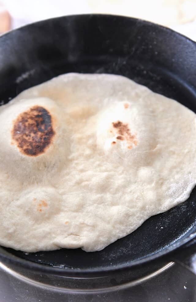 Flatbread cooking in cast iron skillet.