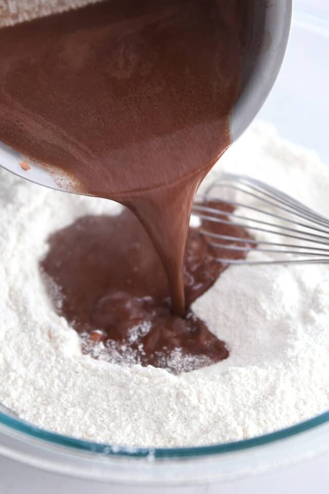 Pouring melted cocoa powder and butter over flour and salt.