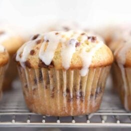 Glazed cinnamon roll muffin on cooling rack.