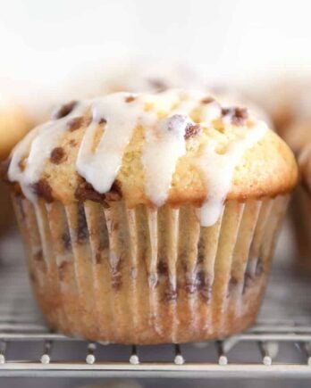 Glazed cinnamon roll muffin on cooling rack.