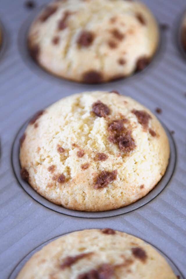 Baked cinnamon roll muffin in muffin tin.