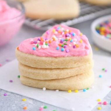 Frosted sugar cookie stacked on two unfrosted sugar cookies.