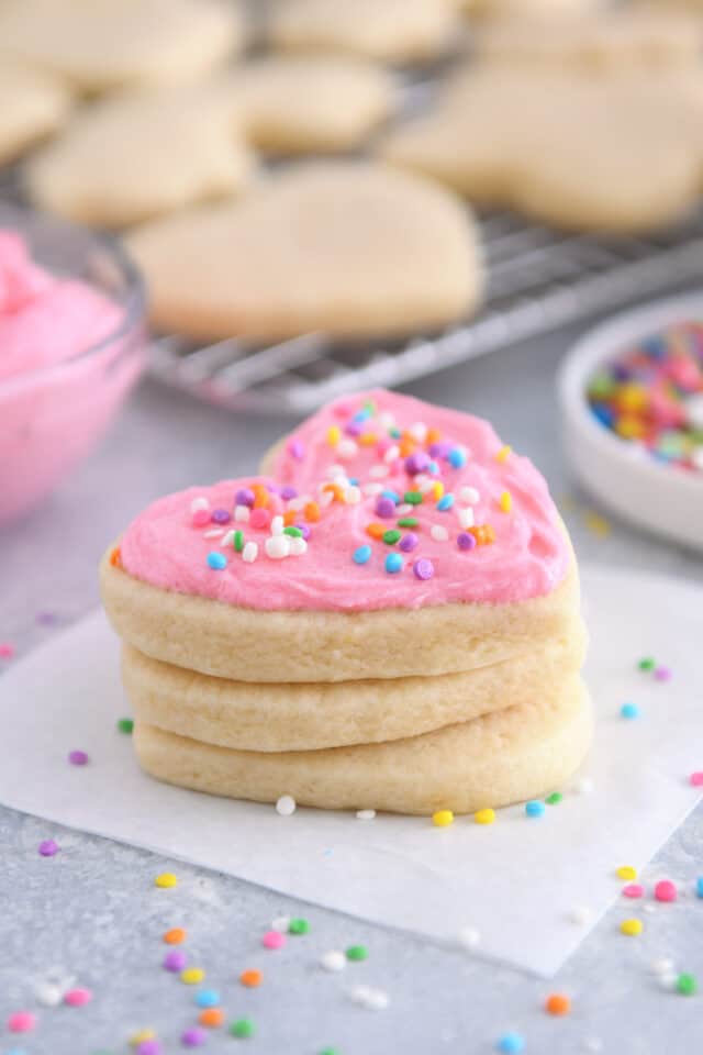 Heart shaped sugar cookie with pink frosting and sprinkles.