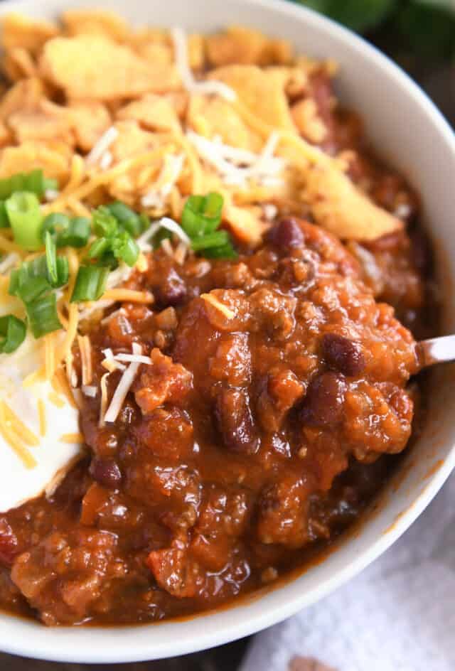 Red chili with ground beef and beans in gray bowl.