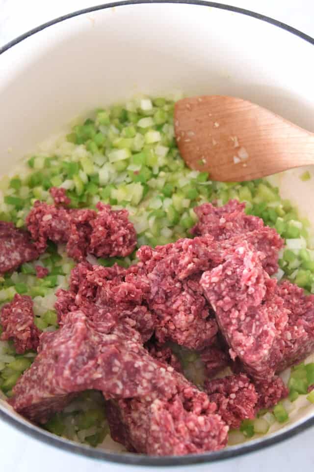 Cast iron pot with ground beef, celery and onions.