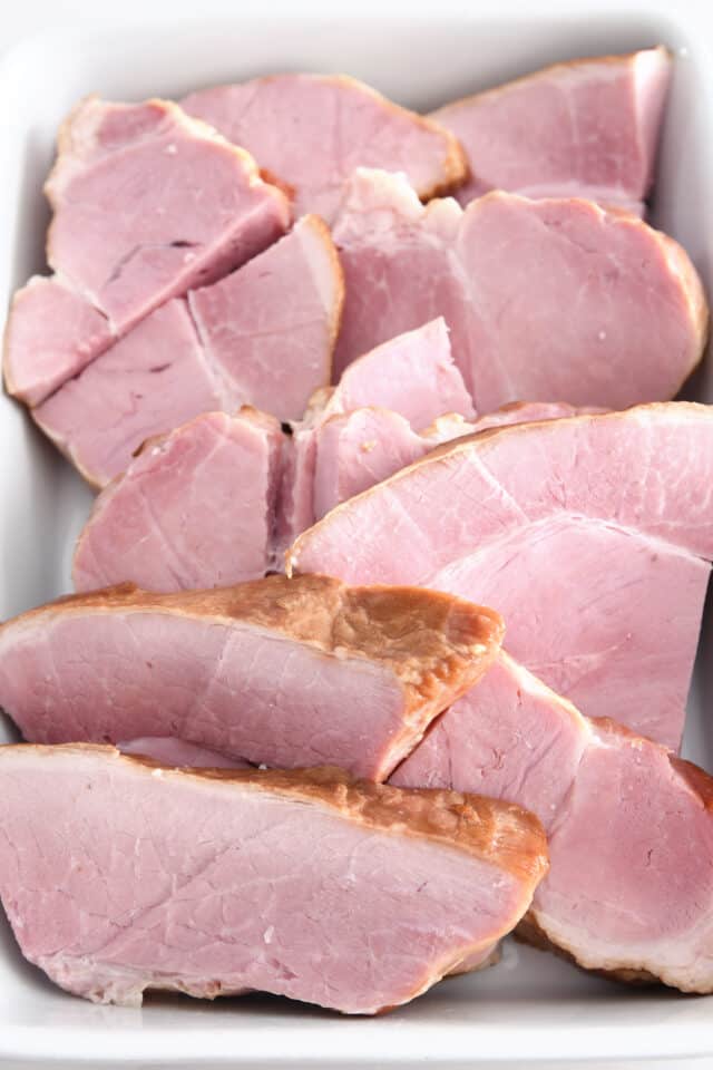 Ham slices in white dish.