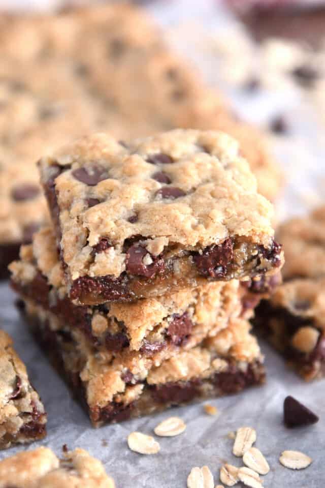 Three stacked square oatmeal chocolate chip cookie bars.