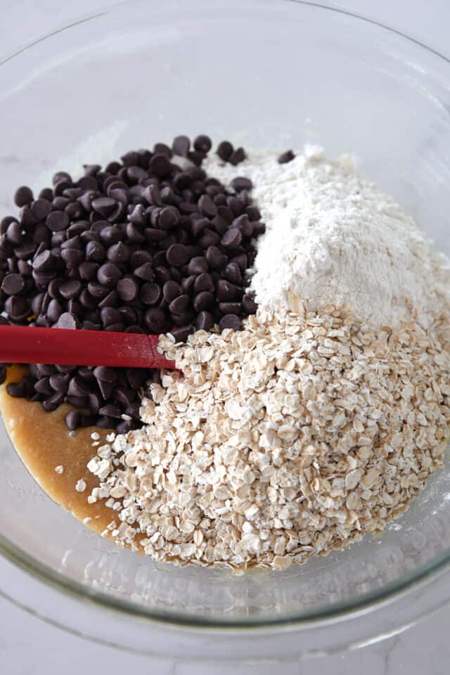 Glass bowl with chocolate chips, flour and oatmeal.