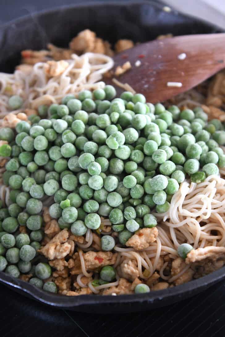 Frozen peas in cast iron skillet with ramen noodles.