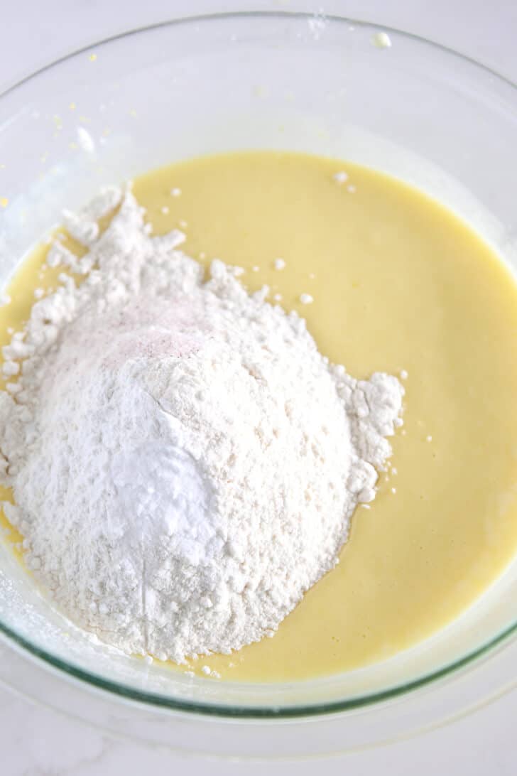 Cake batter in glass bowl with all-purpose flour, salt and baking powder.
