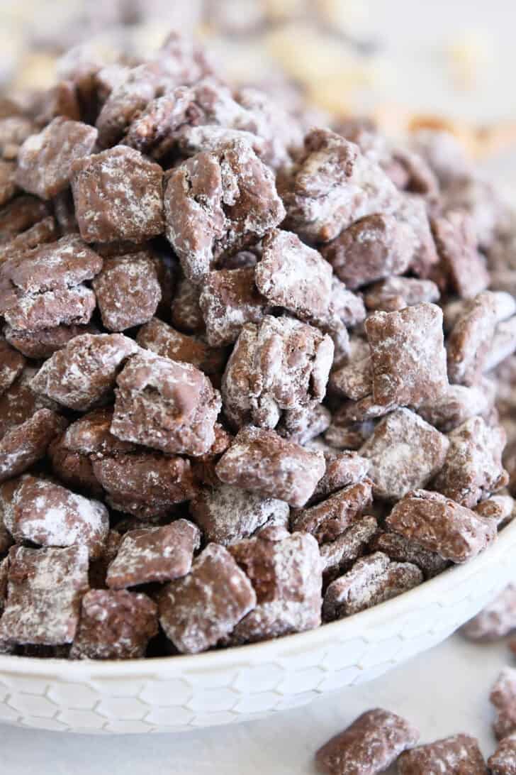 Bowl filled with a towering pile of peanut butter and chocolate puppy chow.