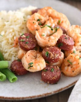 Gray plate with green beans, white rice, shrimp and sausage.