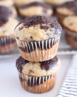 Two banana chocolate swirl muffins stacked on top of each other.