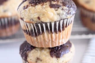 Two banana chocolate swirl muffins stacked on top of each other.