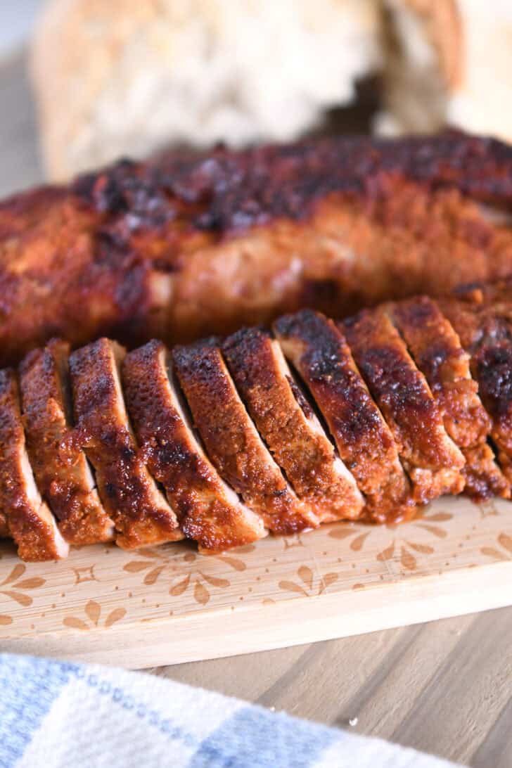 Slices of fried pork tenderloin on wood cutting board.