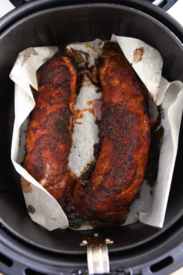 Two pork tenderloin on parchment.