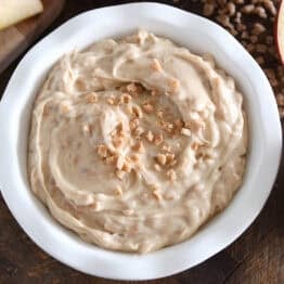 White bowl with toffee apple dip and toffee bits on top.