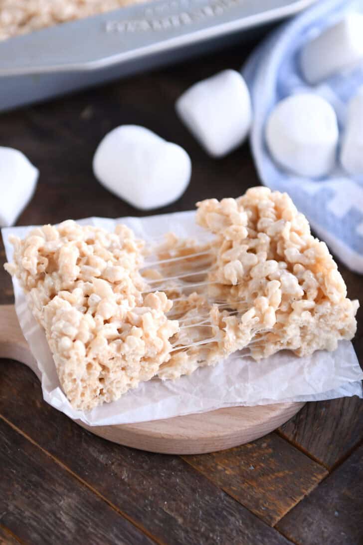 A rice krispie treat split in half on a piece of parchment.