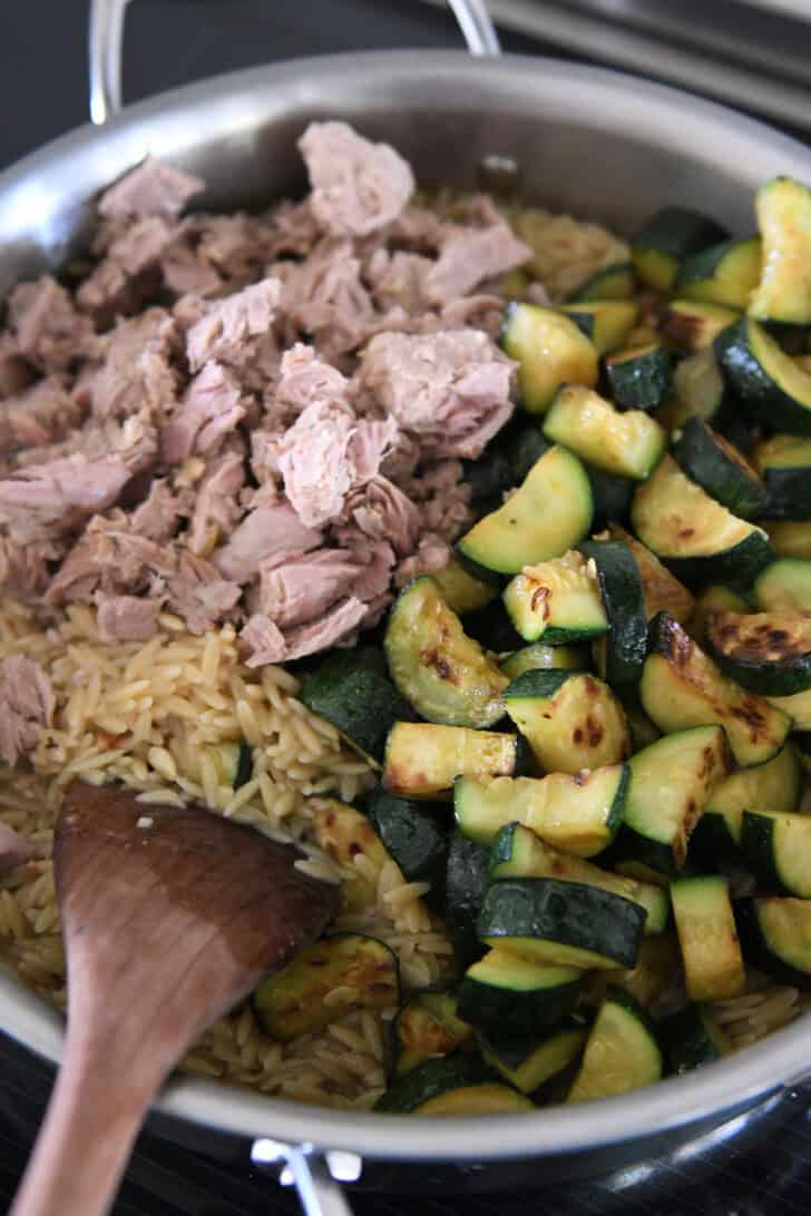 Stainless skillet with tuna, zucchini and orzo pasta.