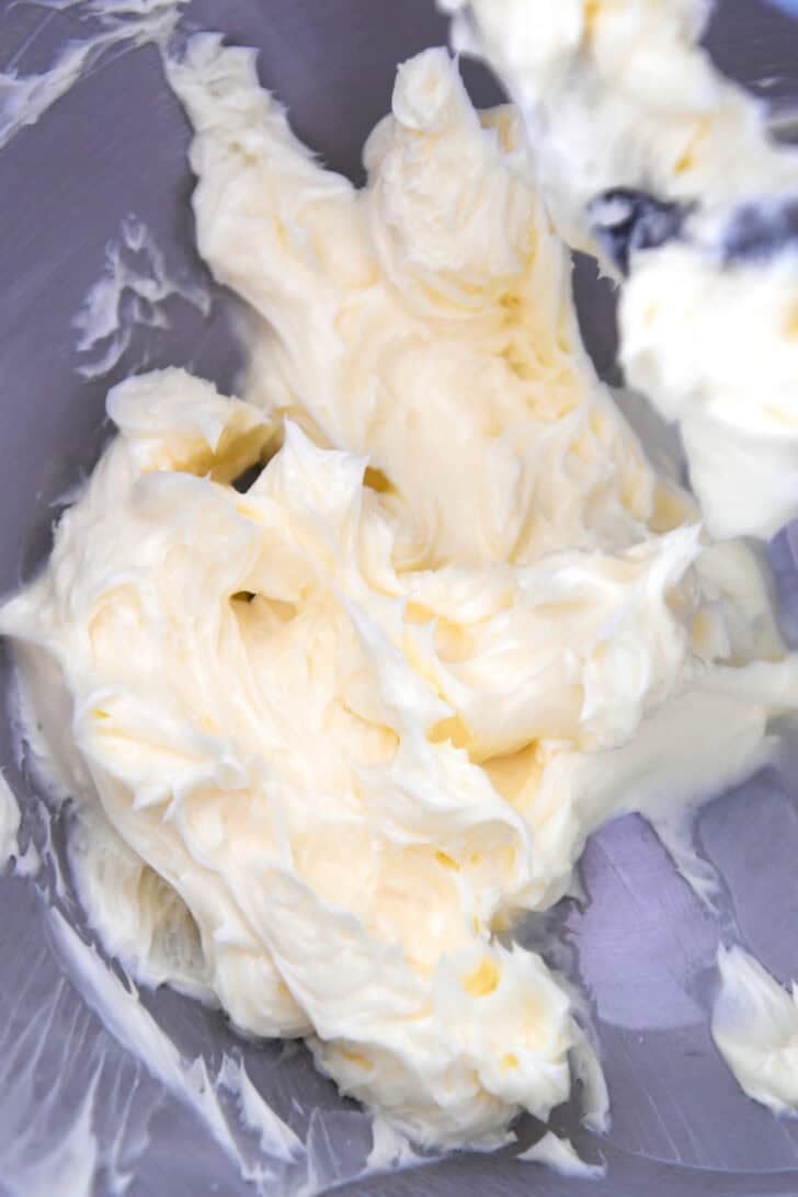 Top down view of a metal mixing bowl with creamed butter.