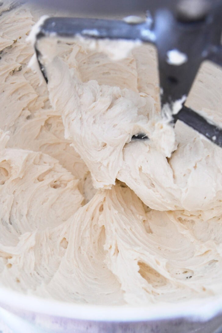 Top down view of a mixing bowl with white frosting.