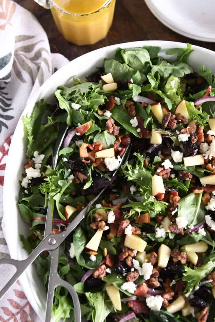 White Bowl with mobile phones and mixed salad of children, apples, feta cheese, cooked bacon, craisin and thigh seeds.