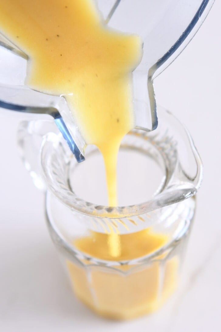 Pouring Apple cider vinaigrette in jar jar.