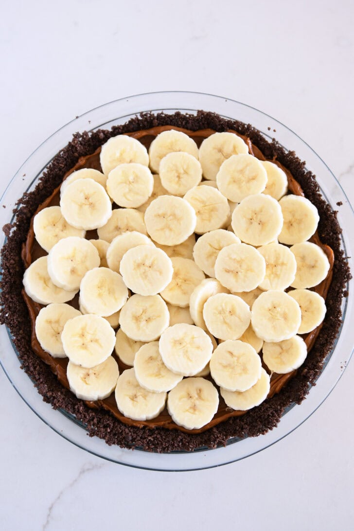 Sliced fresh bananas layered across dulce de leche in chocolate cookie crust in 9-inch glass pie plate.