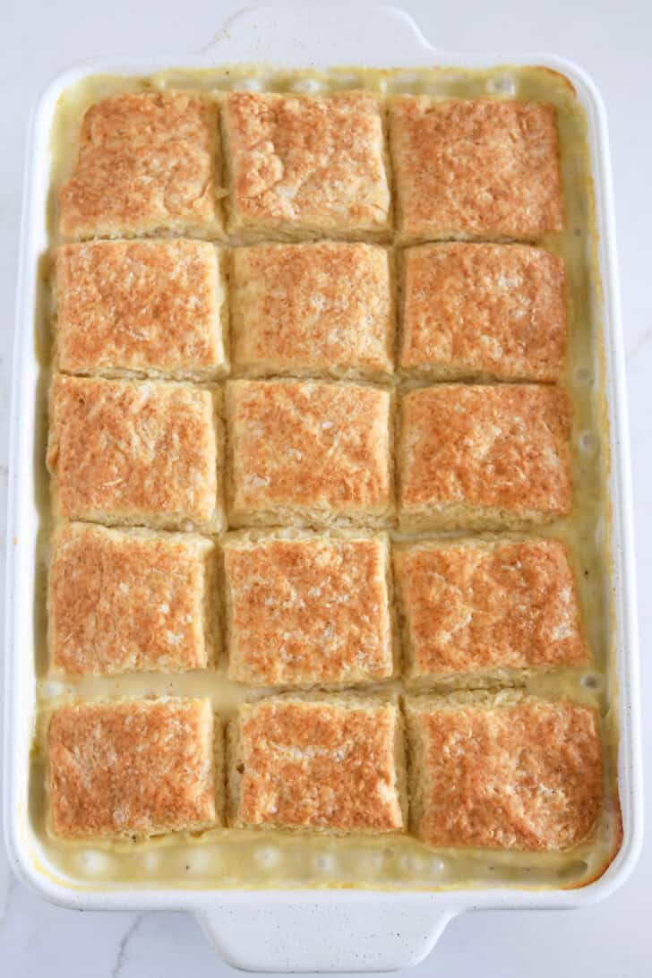 White 9X13-inch pan with baked biscuits and bubbling chicken pot pie filling.