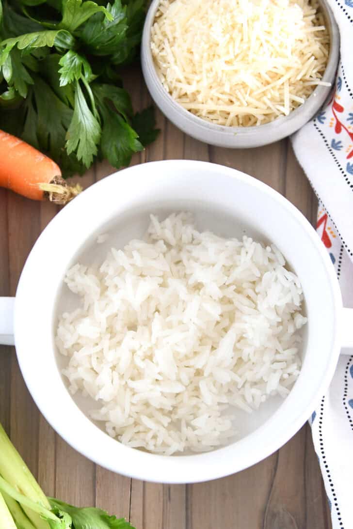 White soup bowl with handles with scoop of white rice in the bottom.