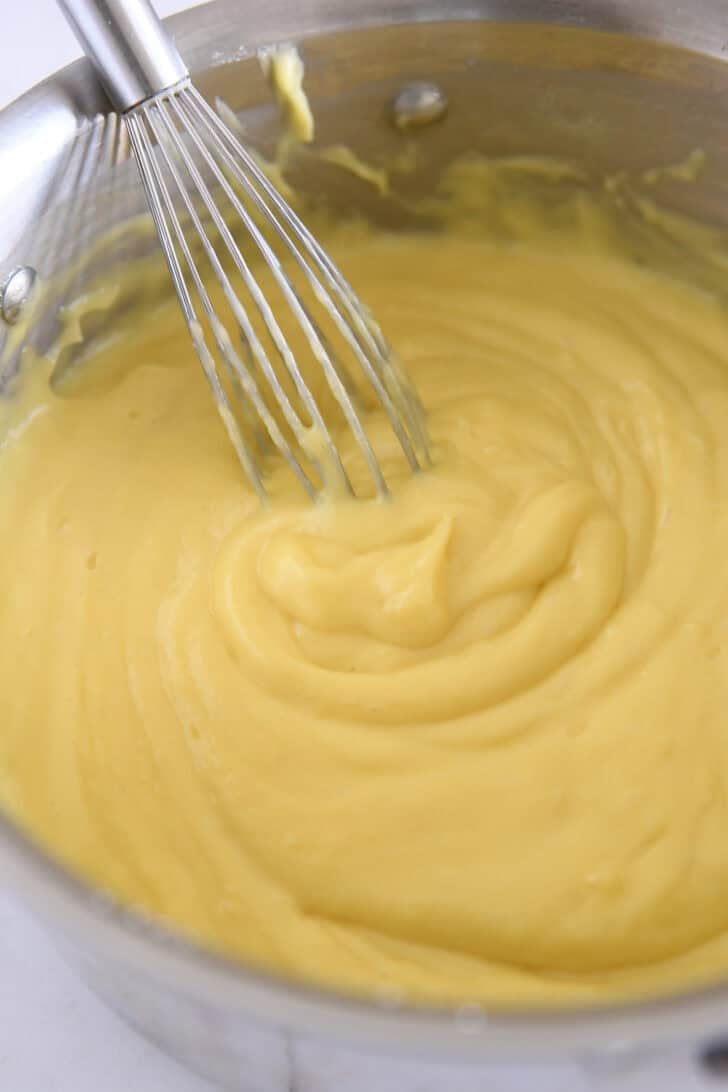 Whisking vanilla coconut pudding in stainless pot.