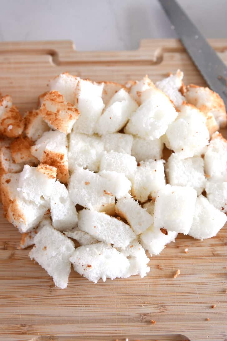 Cutting board with cubed angel food cake.