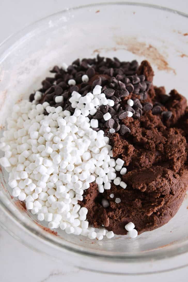 Glass bowl with chocolate cookie dough, chocolate chips and mini marshmallow bits.
