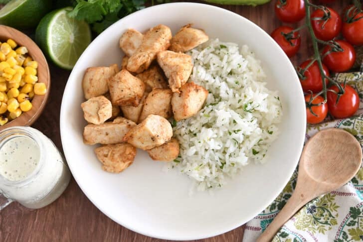White bowl with cilantro lime rice and cooked chicken.