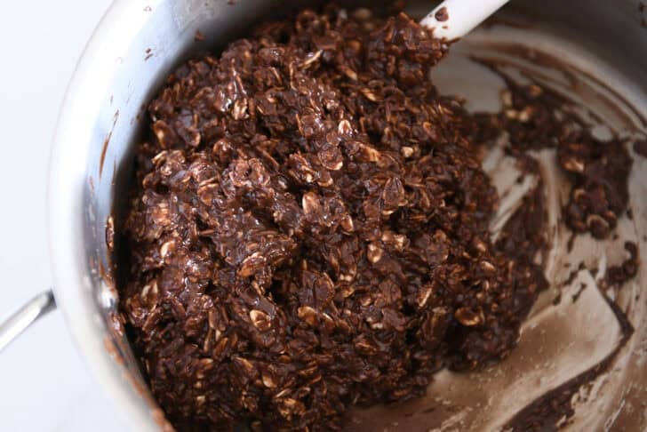 Saucepan with chocolate no-bake cookie batter and white rubber spatula.