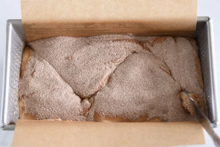 Using a butter knife, swirl the cinnamon sugar mixture and quickbread dough.