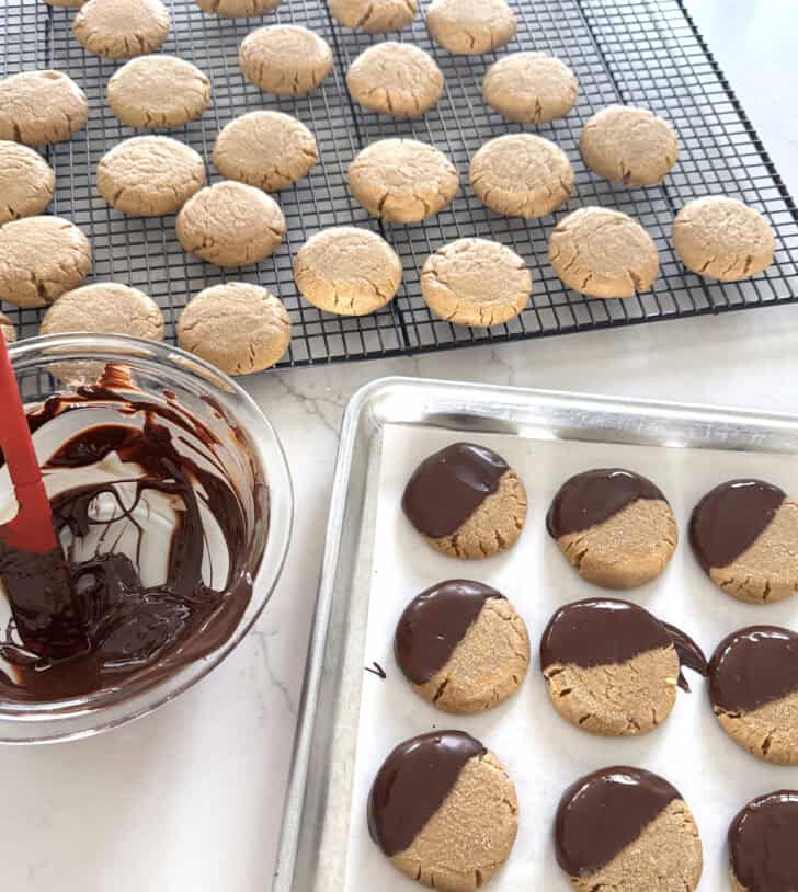 Peanut butter cookies on cooling rack with melted chocolate.
