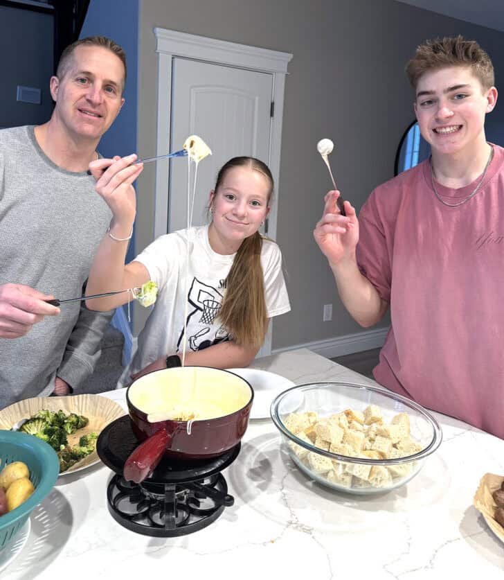 Family eating cheese fondue.