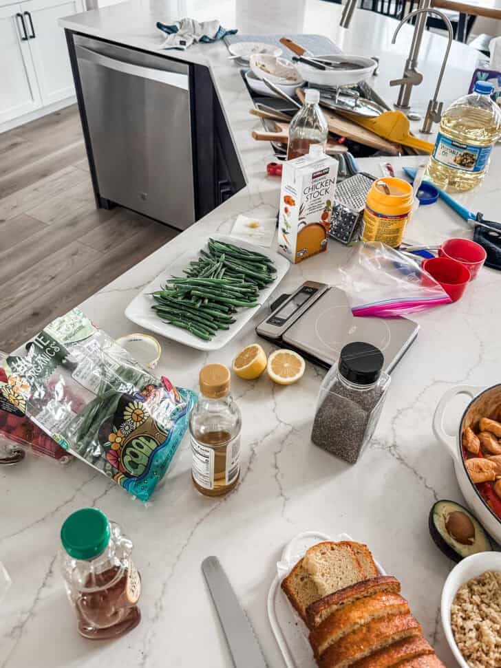 Messy kitchen counter with sink full of dishes.