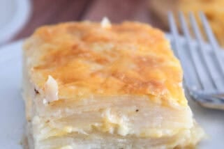 Square of baked au gratin potatoes on gray plate.