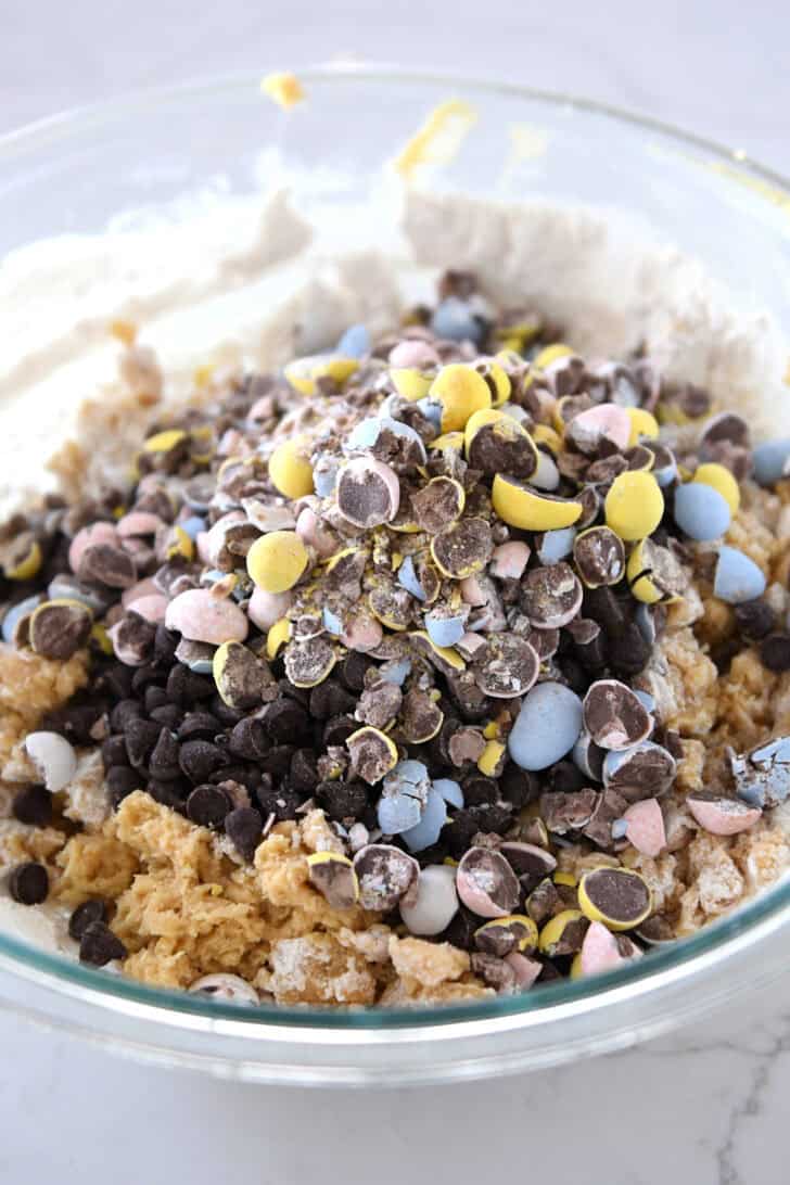 Glass bowl with cookie batter, chocolate chips and crushed cadbury eggs.