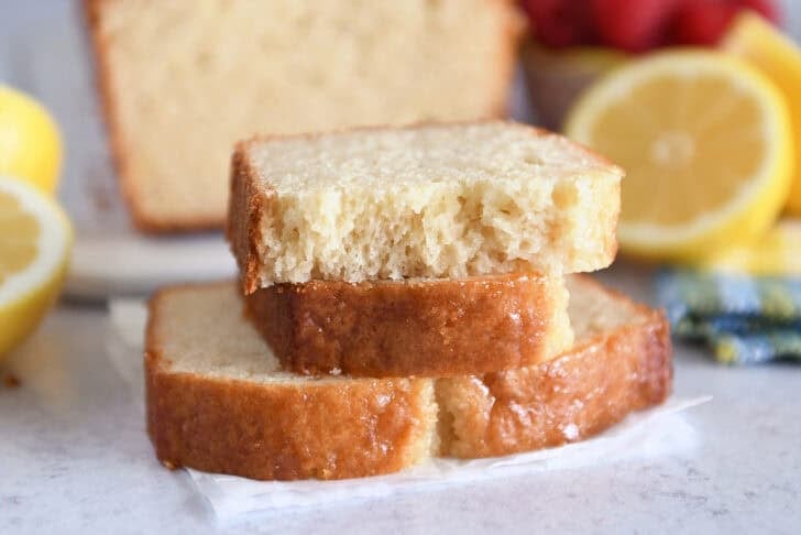 Two half slices of lemon yogurt bread stacked on one full slice.