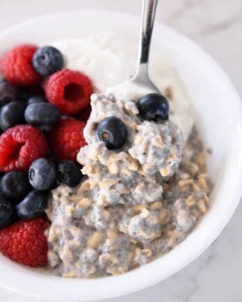 White bowl with chia oats, blueberries, and raspberries.