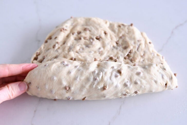 Rolling up loaf of cinnamon burst bread dough.