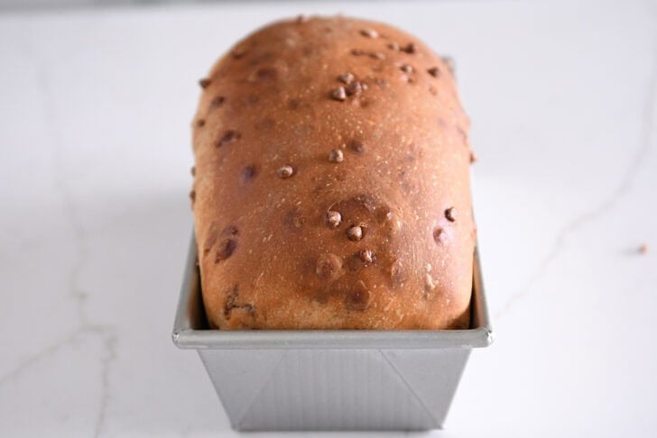 Baked loaf of cinnamon burst bread in loaf pan.