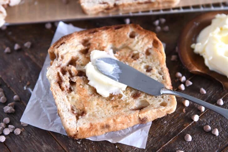 Pat of butter spread on toasted cinnamon burst bread.